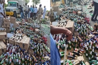 Nagar kurnool passers by picked up liqour bottles as a truck overturns